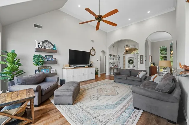 a living room with furniture a flat screen tv and a window