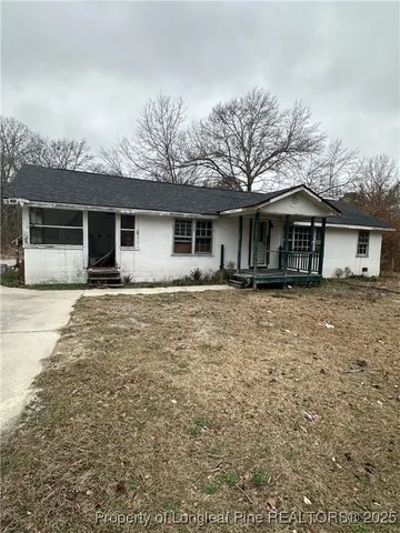 a front view of house with yard and trees around