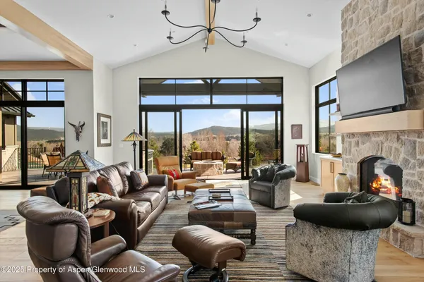 a living room with furniture a fireplace and a floor to ceiling window