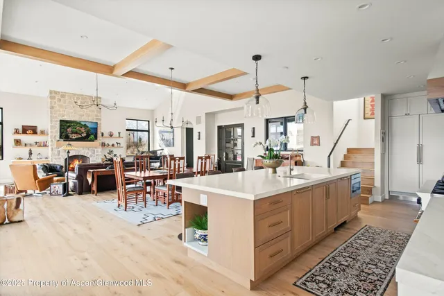 a large white kitchen with sink and a large window
