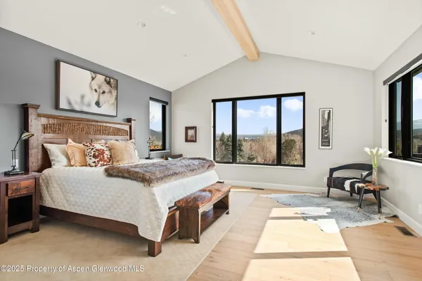 a spacious bedroom with a large bed and a large window