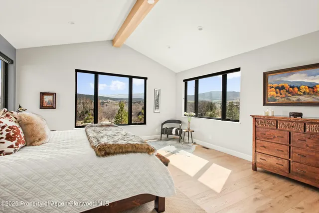 a bedroom with a bed and large windows