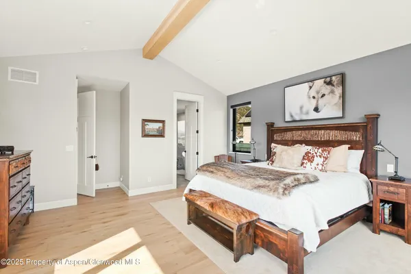 a bedroom with a bed and painting on the wall