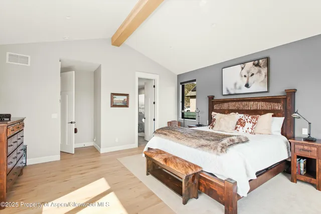 a bedroom with a bed and painting on the wall