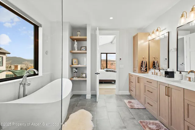 a large bathroom with a double vanity sink a mirror and a bathtub
