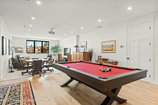a living room with furniture pool table and rug
