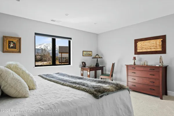 a bedroom with a bed and large window