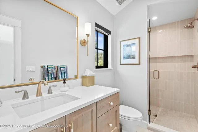 a bathroom with a sink vanity granite toilet and a mirror