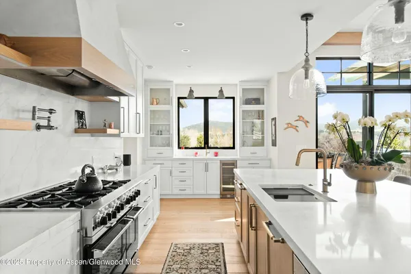 a kitchen with stainless steel appliances a sink a stove and a wooden floor