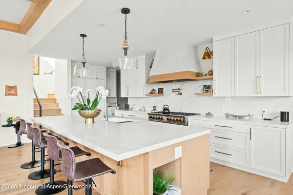 a kitchen with stainless steel appliances kitchen island granite countertop a sink a stove and white cabinets