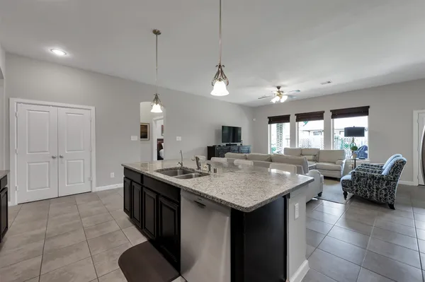 a living room with furniture a flat screen tv and kitchen view