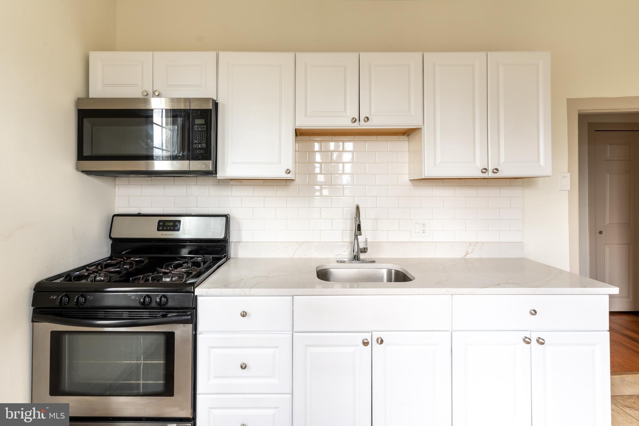 100 Potter Street, Unit 4 Haddonfield, NJ 08033 - Photo 2 of 17 a kitchen with stainless steel appliances granite countertop white cabinets and a stove a oven with white countertops