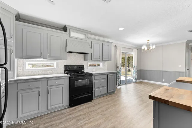 a kitchen with granite countertop a sink cabinets and stainless steel appliances
