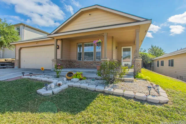 a front view of a house with a yard outdoor seating and garage