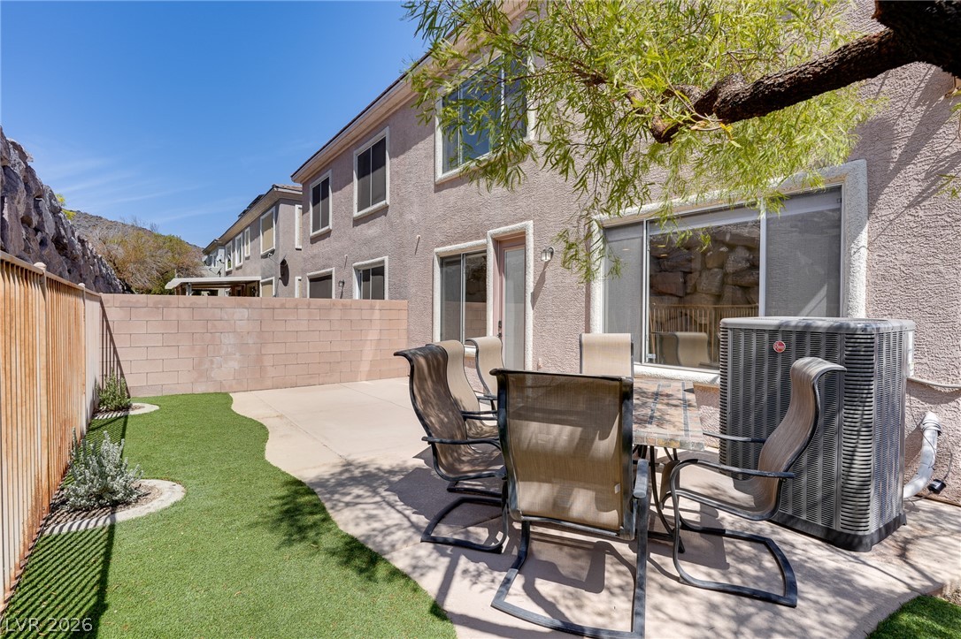 703 Principle Point Avenue Henderson, NV 89012 - Photo 14 of 29 An inviting backyard patio space offers seamless outdoor living, bordered by low-maintenance artificial turf.