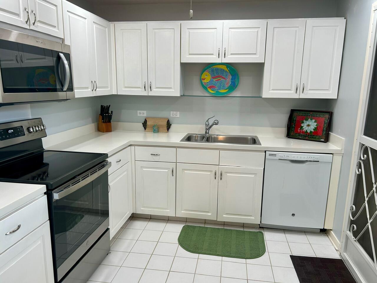 1 Southeast Turtle Creek Drive, Unit B Jupiter, FL 33469 - Photo 4 of 31 a kitchen with stainless steel appliances granite countertop a sink and a stove