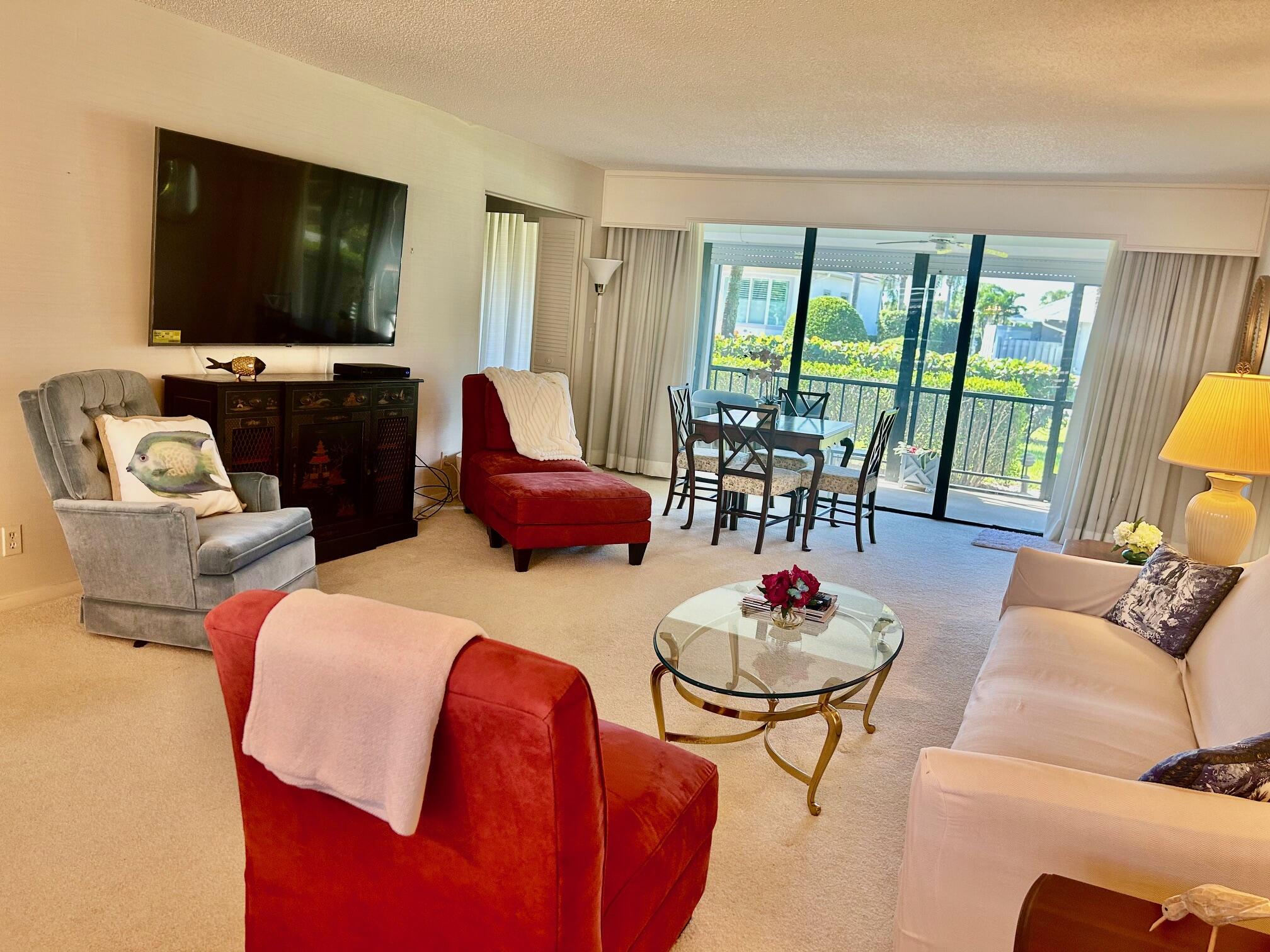 1 Southeast Turtle Creek Drive, Unit B Jupiter, FL 33469 - Photo 8 of 31 a living room with furniture and a flat screen tv