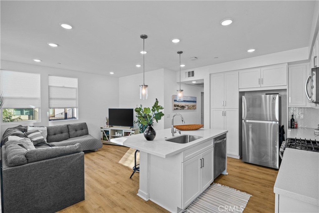 9654 Nova Place Rancho Cucamonga, CA 91730 - Photo 1 of 1 a kitchen that has a lot of cabinets a sink and a wooden floor
