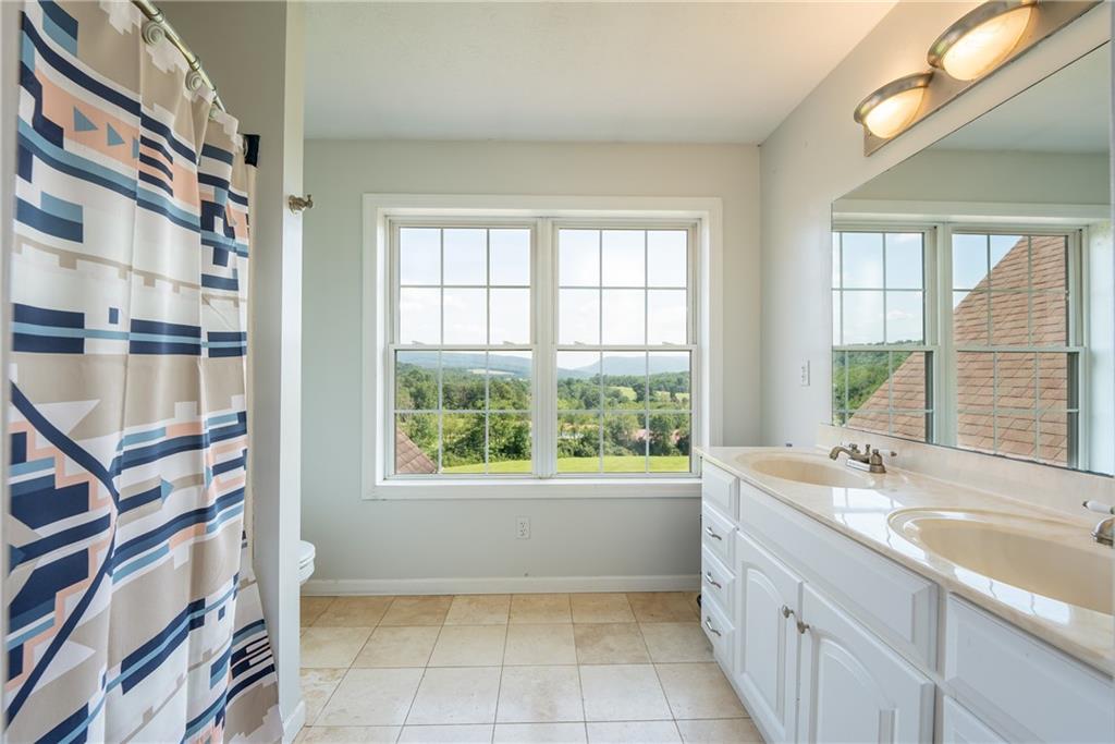 387 George Lane Seward, PA 15954 - Photo 28 of 45 a bathroom with a granite countertop sink a large mirror and a bathtub next to a window