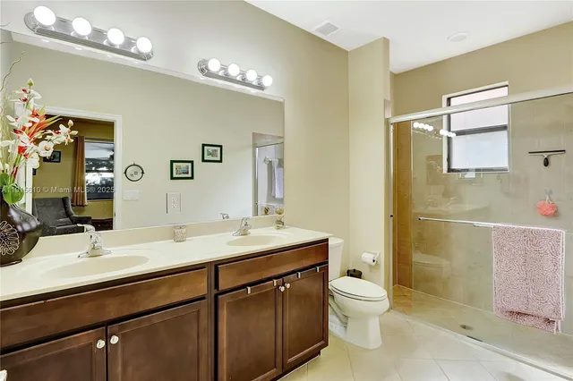 a bathroom with a granite countertop sink toilet a large mirror a shower and vanity
