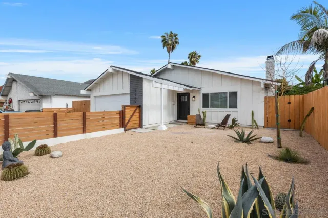 a view of a house with backyard and sitting area
