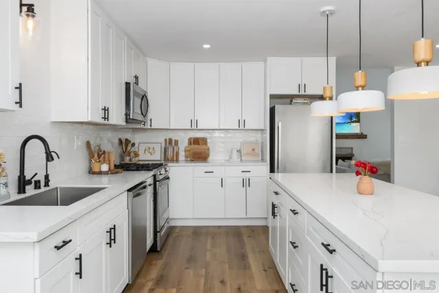 a kitchen with a sink a stove a refrigerator and cabinets