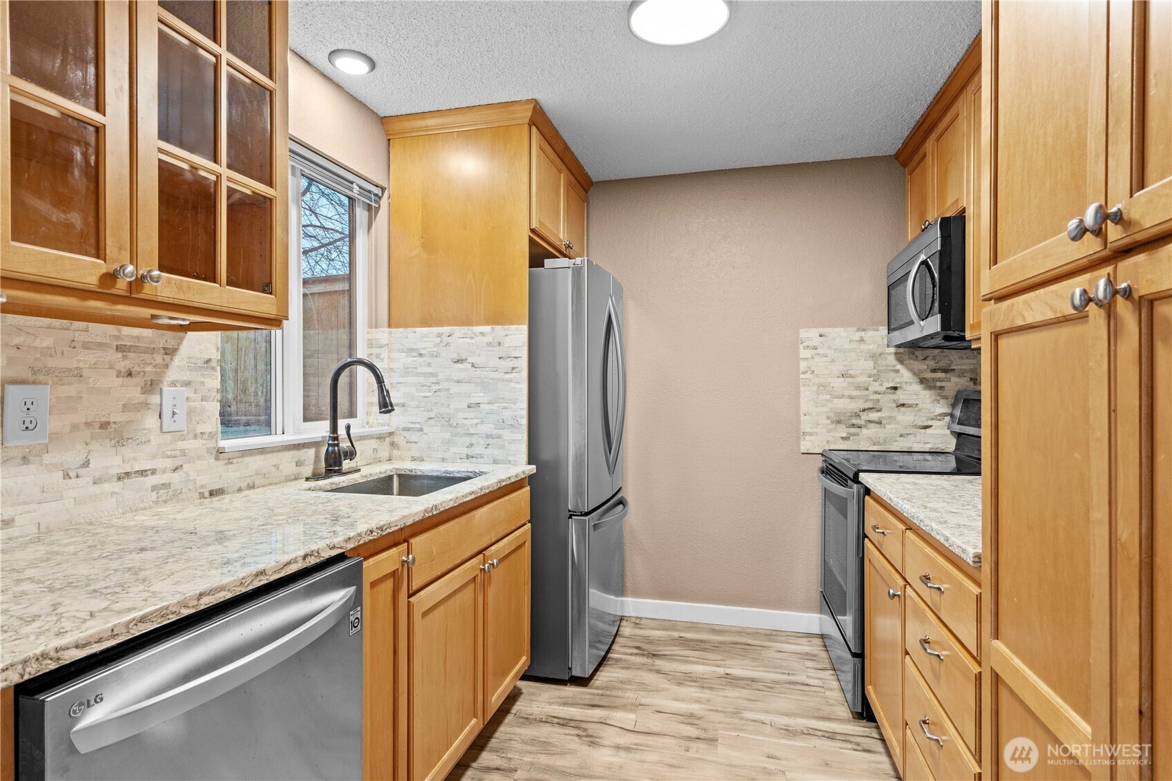 17303 Spanaway Loop Road South, Unit 4 Spanaway, WA 98387 - Photo 9 of 33 a kitchen with stainless steel appliances granite countertop a refrigerator and a sink
