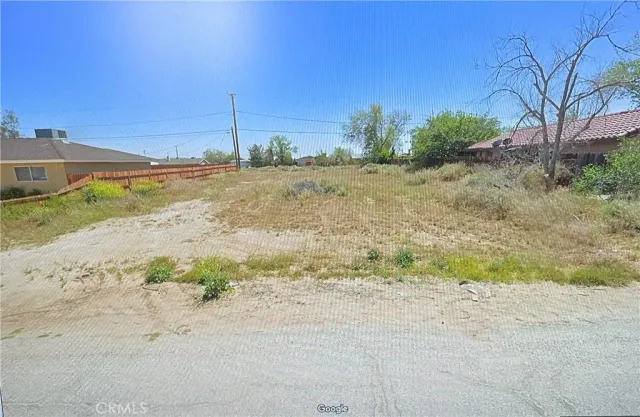 a view of a dirt road with a building in the background