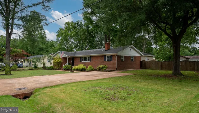 a front view of a house with a yard and trees