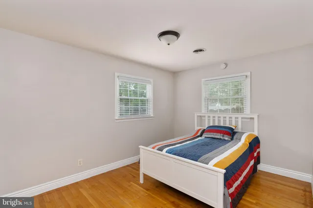 a bedroom with a bed and a chandelier fan