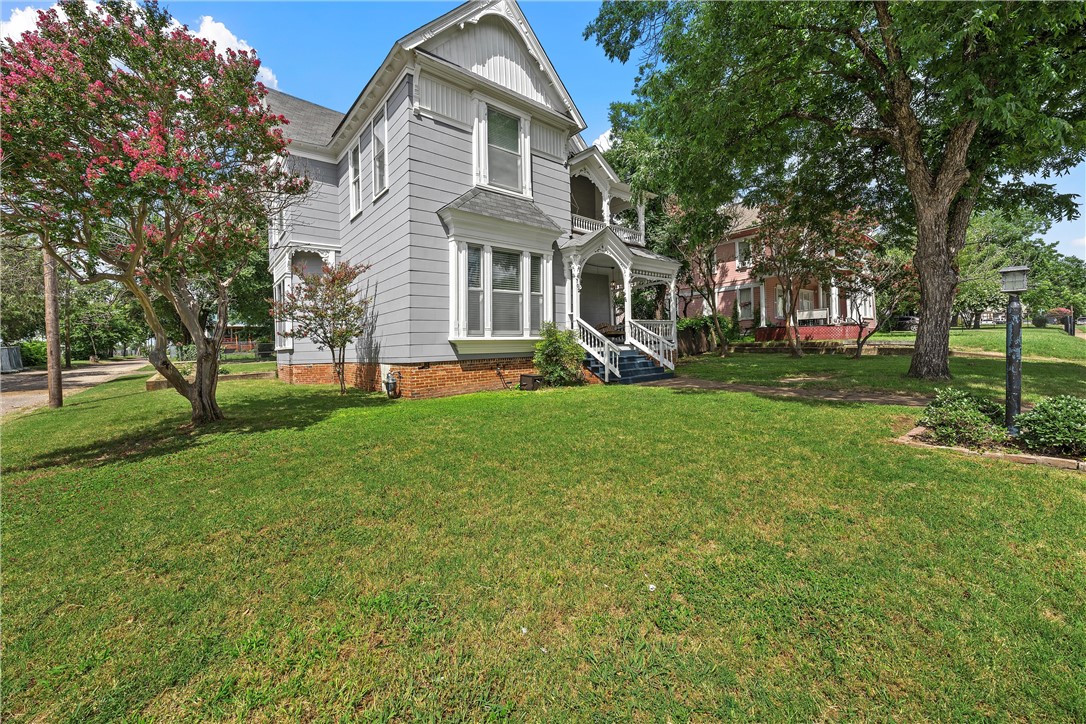 702 North 15th Street Waco, TX 76707 - Photo 3 of 45 a front view of a house with garden and trees