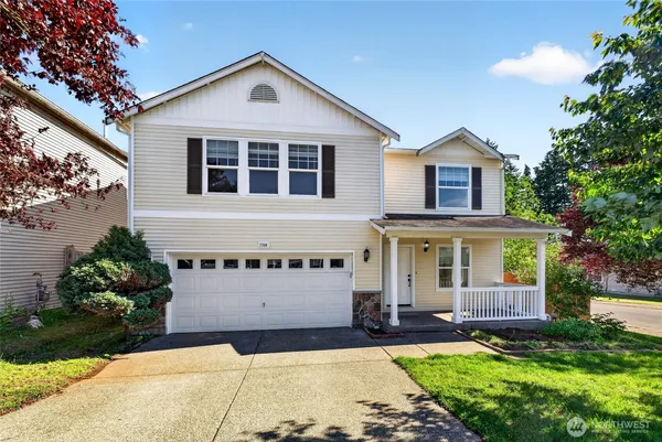 a front view of a house with a yard and garage