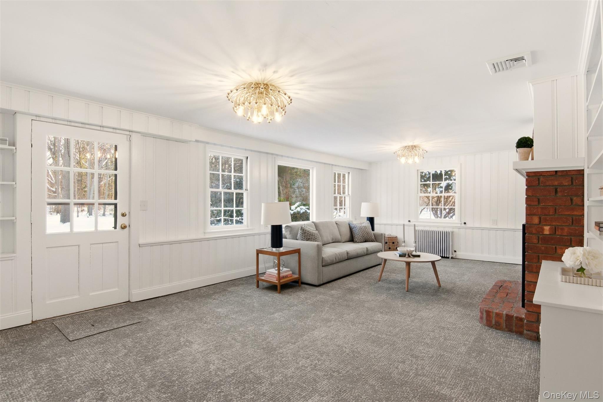 55 White Hill Road Cold Spring Harbor, NY 11724 - Photo 12 of 13 a living room with furniture and chandelier