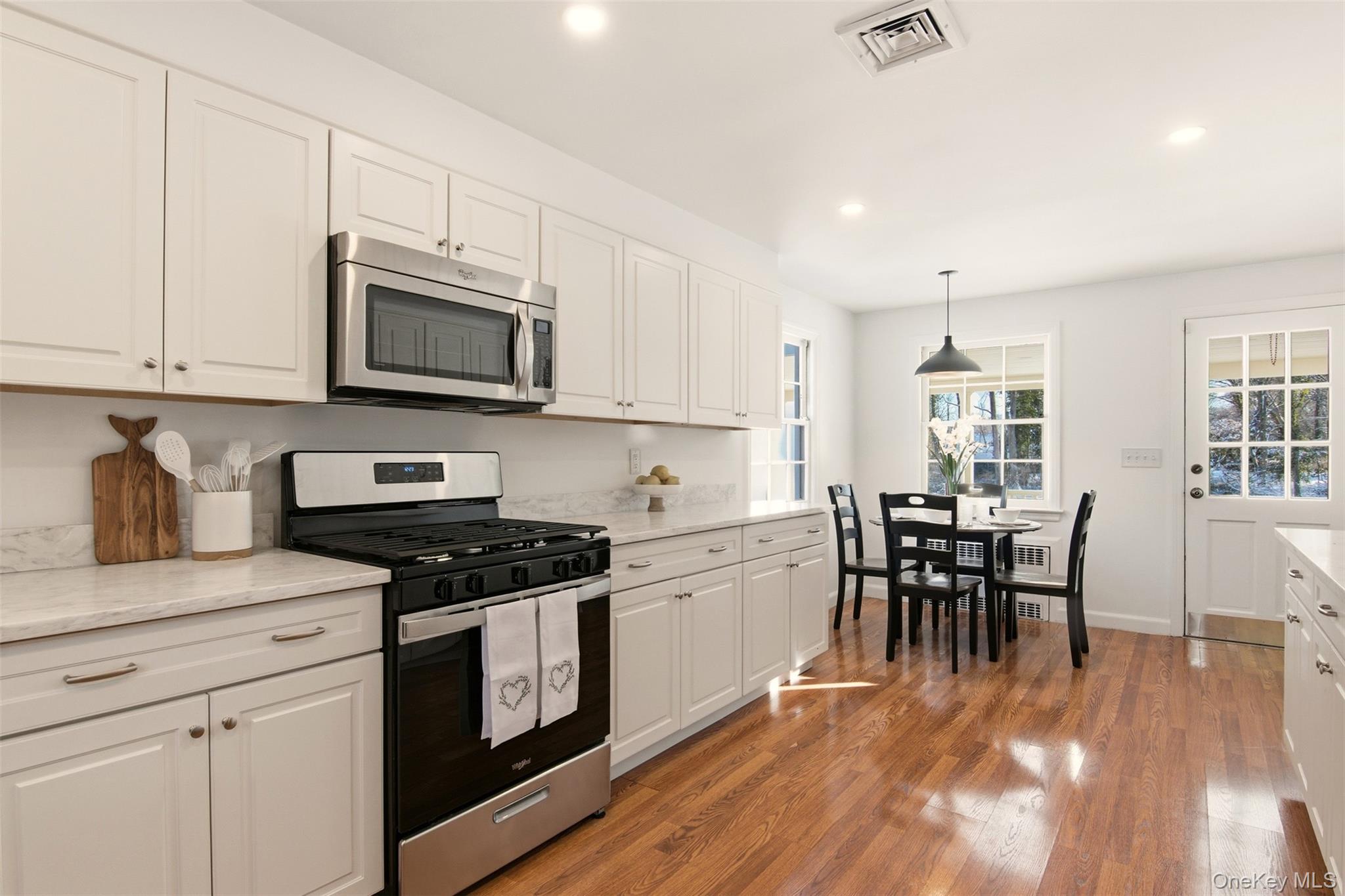 55 White Hill Road Cold Spring Harbor, NY 11724 - Photo 8 of 13 a kitchen with granite countertop cabinets stainless steel appliances a dining table and chairs