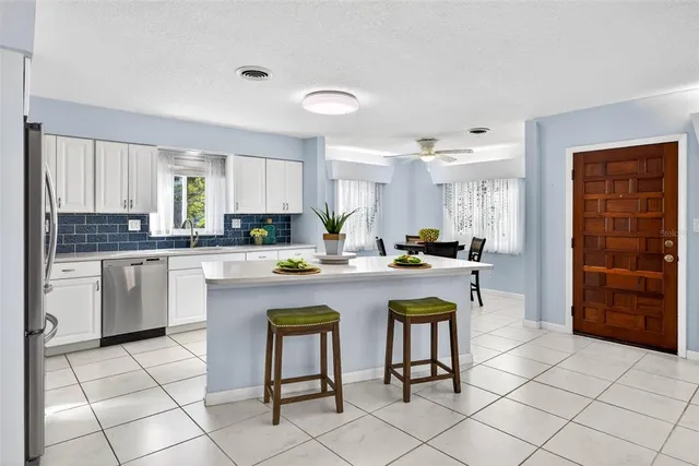 a kitchen with white cabinets and appliances