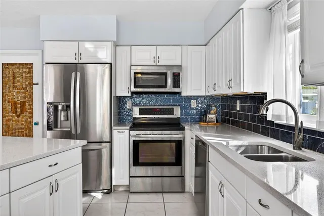 a kitchen with stainless steel appliances granite countertop a refrigerator sink and stove