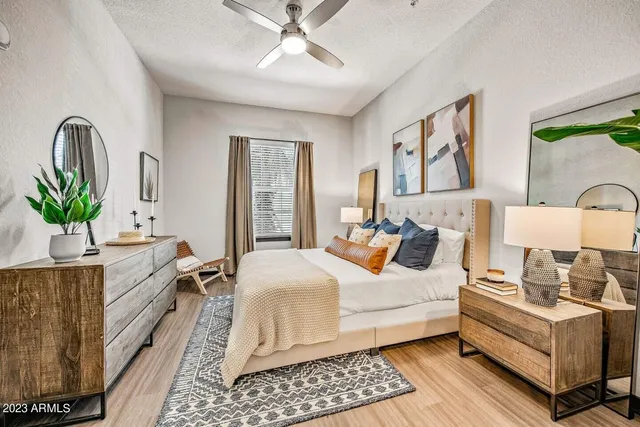 a bedroom with a bed wooden floor and window