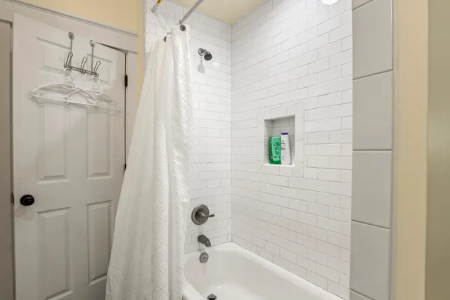 a bathroom with a bathtub a shower and a sink