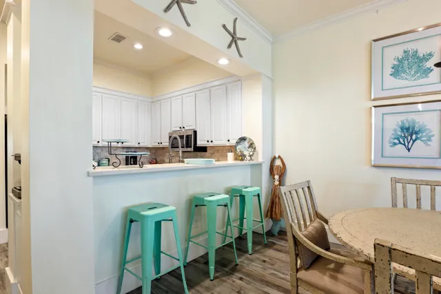 a kitchen with stainless steel appliances granite countertop a dining table chairs and a refrigerator