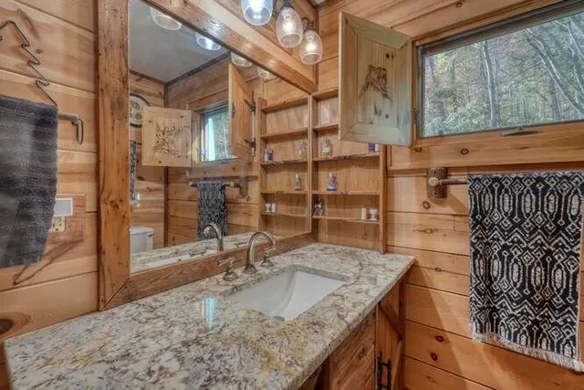 a bathroom with a sink a toilet and shower