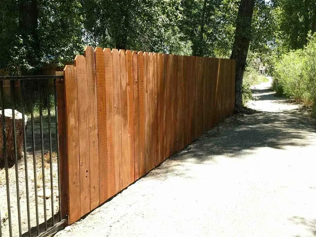 a view of a deck with a large window and wooden fence