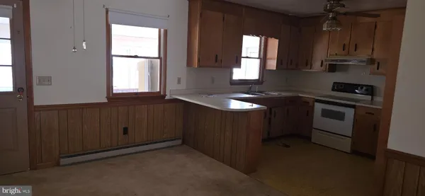 a kitchen with granite countertop a sink stove and cabinets