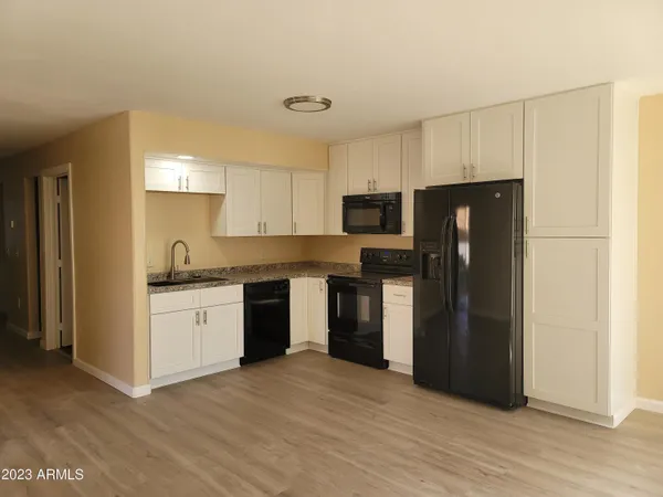 a kitchen with a refrigerator sink and cabinets
