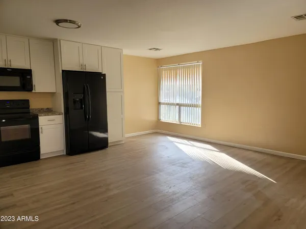 a view of an empty room with closet and a window