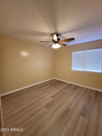 a view of a room with wooden floor and fan