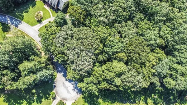 an aerial view of a house with a yard and swimming pool