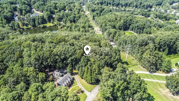 an aerial view of a house with a yard and large trees