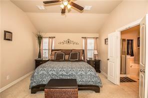 1409 Rosson Road Little Elm, TX 75068 - Photo 3 of 34 Vaulted ceiling bedroom with a ceiling fan light fixture, two windows with window treatments, and an open doorway leading to a bathroom with a built-in tub