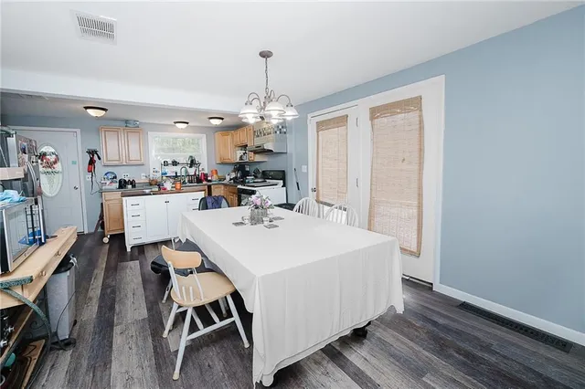 a view of a dining room with furniture wooden floor and chandelier