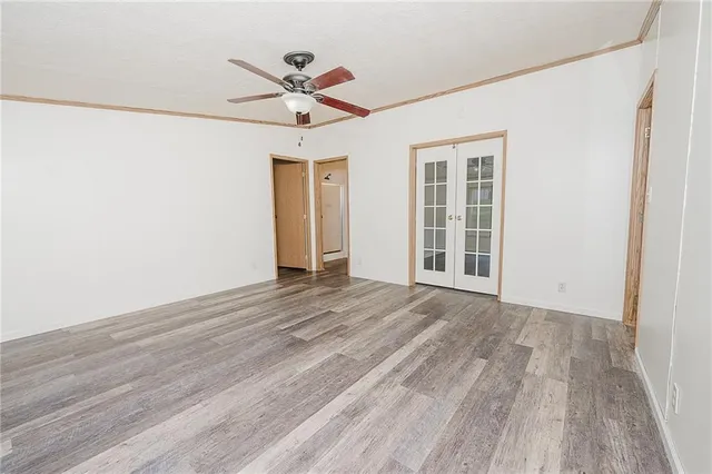 a view of an empty room with a window and wooden floor